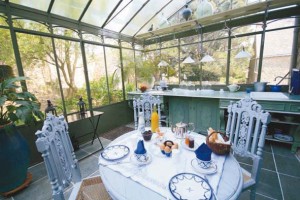 La magnifique verrière à  l’ancienne donne à la salle à manger un cachet inimitable. Dans cette pièce à  " ciel ouvert ", la table et les chaises  d’inspiration XVIème ont été décapées  et repeintes. Au fond, un grand plan de travail a été installé sur toute la largeur de la pièce. 