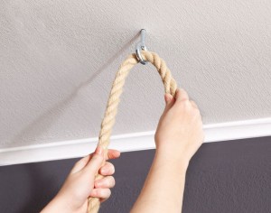 Fixer la table de chevet au plafond. Pour ce faire, il suffit de passer les longues cordes à travers les crochets et les fixer avec des nœuds. 