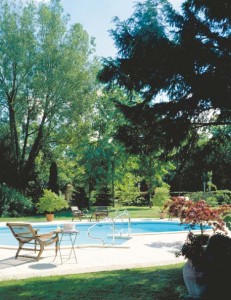 La piscine a été construite à la place de l’ancien potager. Elle est entourée de murets en pierre du pays. Chaise de planteur d’origine sud est asiatique datant de 1880, chinée à la braderie de Lille.