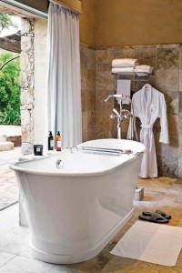 Dans la salle de bains, la baignoire émaillée avec sa robinetterie années 20 est posée sur un sol marbre zébra. 